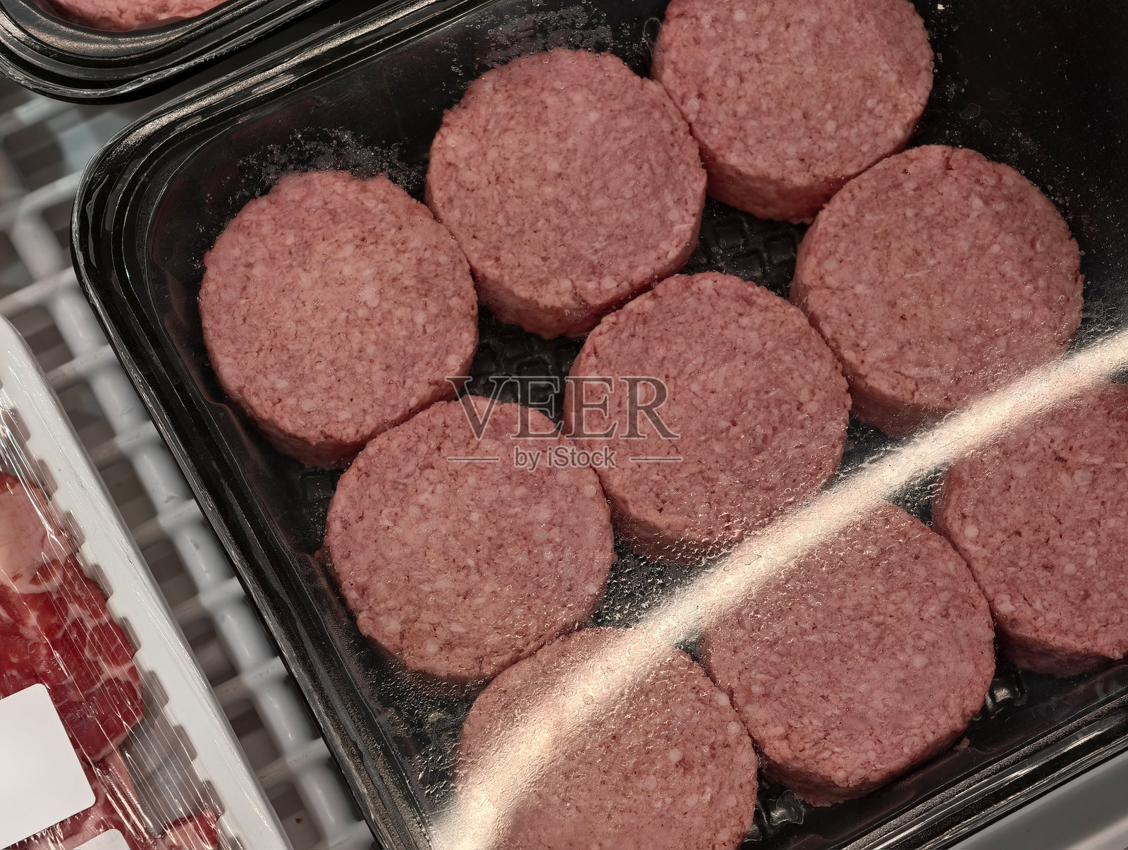 零售冰箱展示柜中包装好的冷冻牛肉饼照片摄影图片