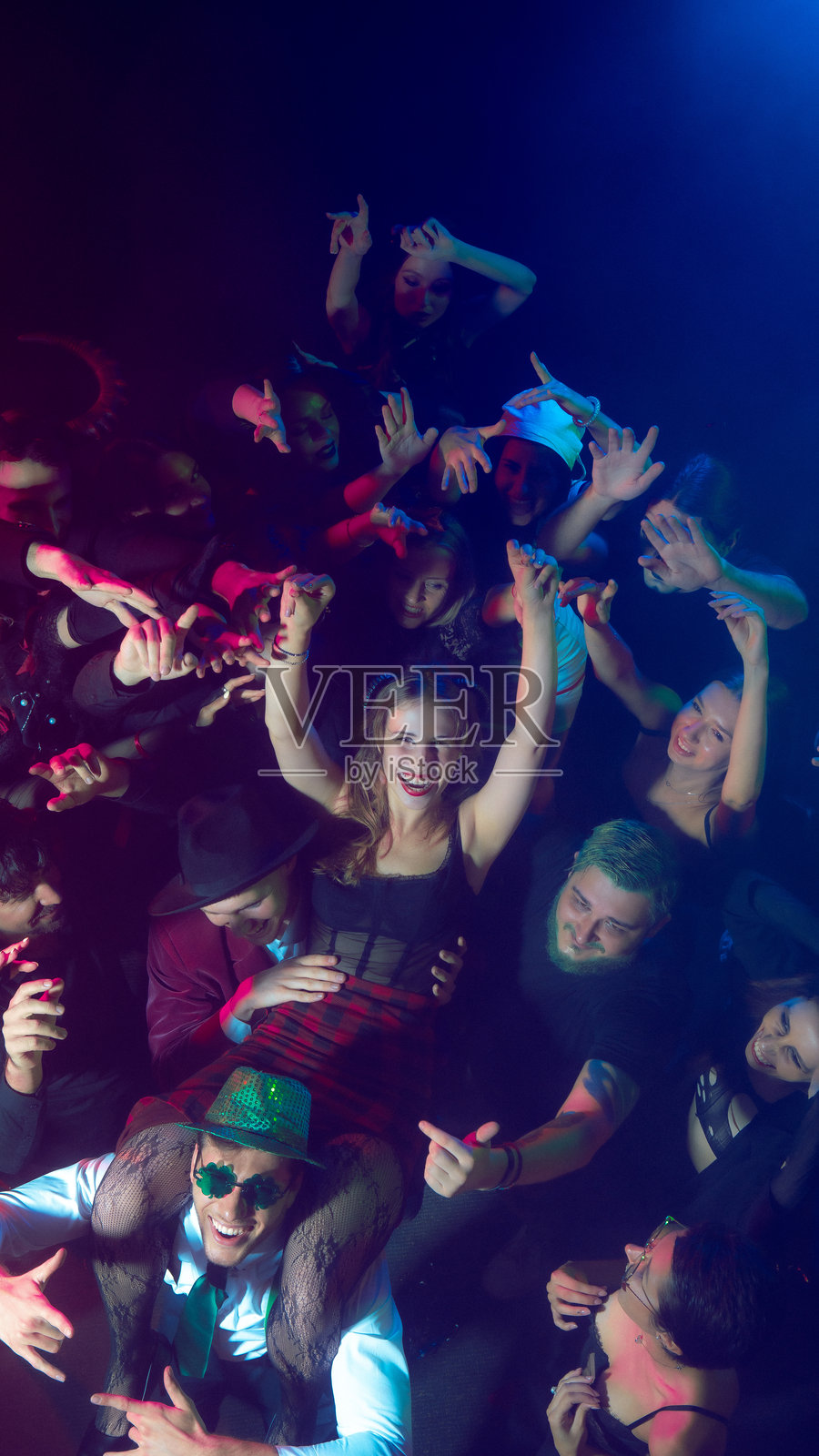 在节日万圣节派对上，人群将一位微笑的女士高高举起。照片摄影图片