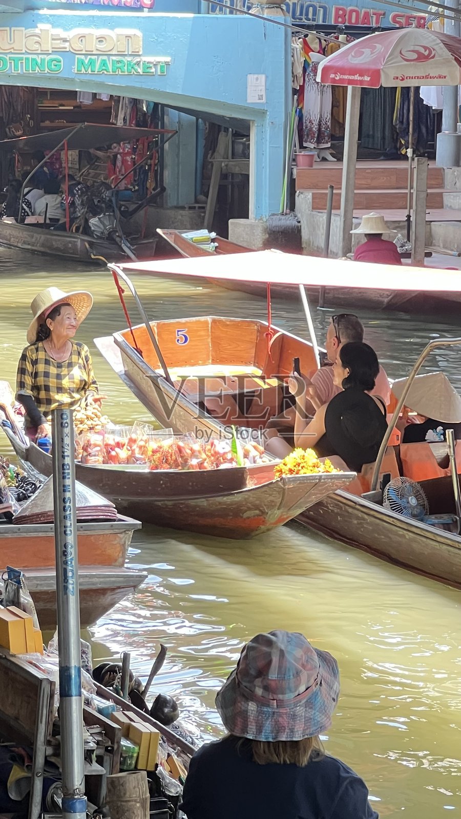 2025年4月20日，泰国叻丕府：泰国著名景点丹嫩沙多水上市场，一位女性船商正在售卖水果。照片摄影图片