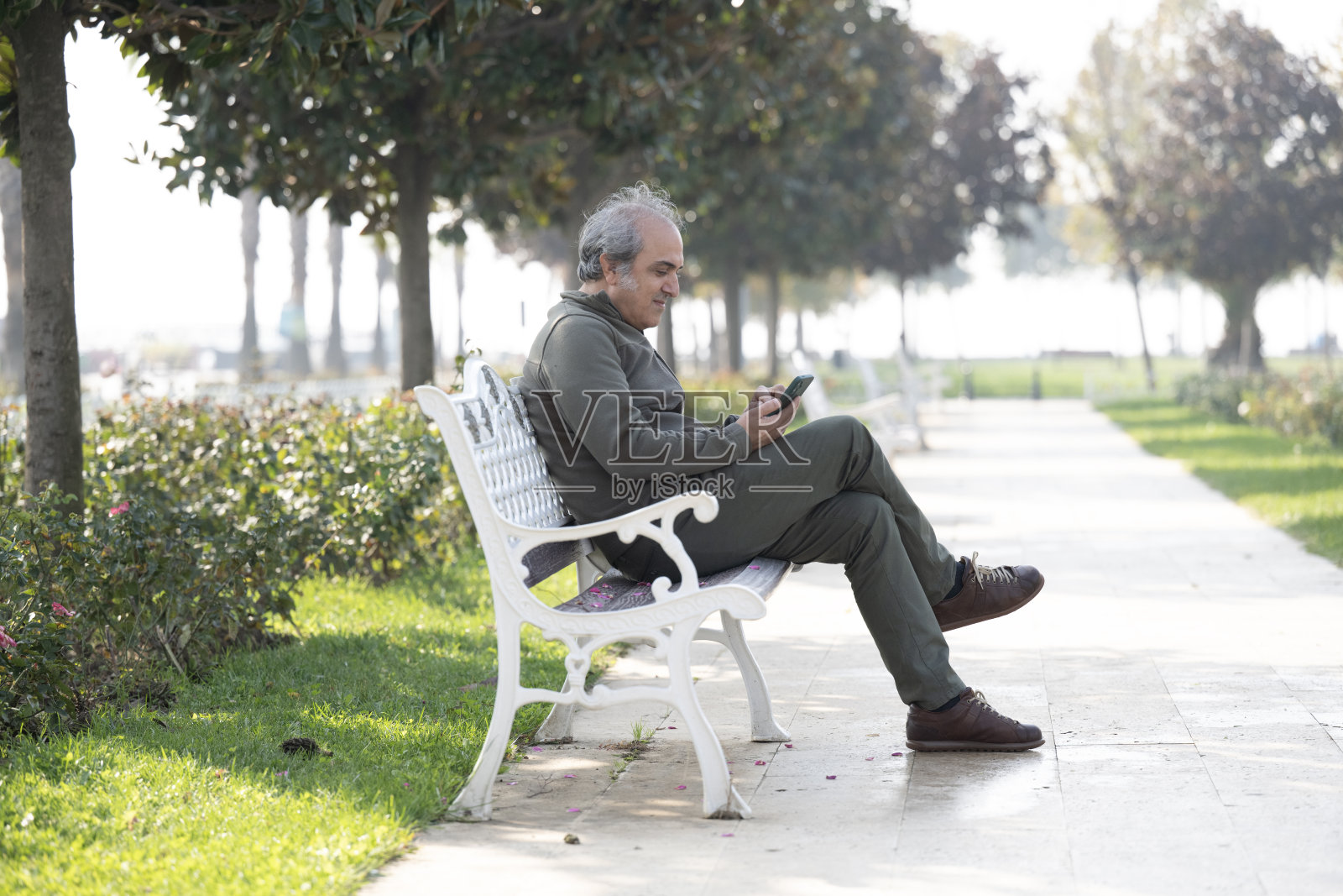 一个男人在公园里玩耍，同时使用智能手机照片摄影图片