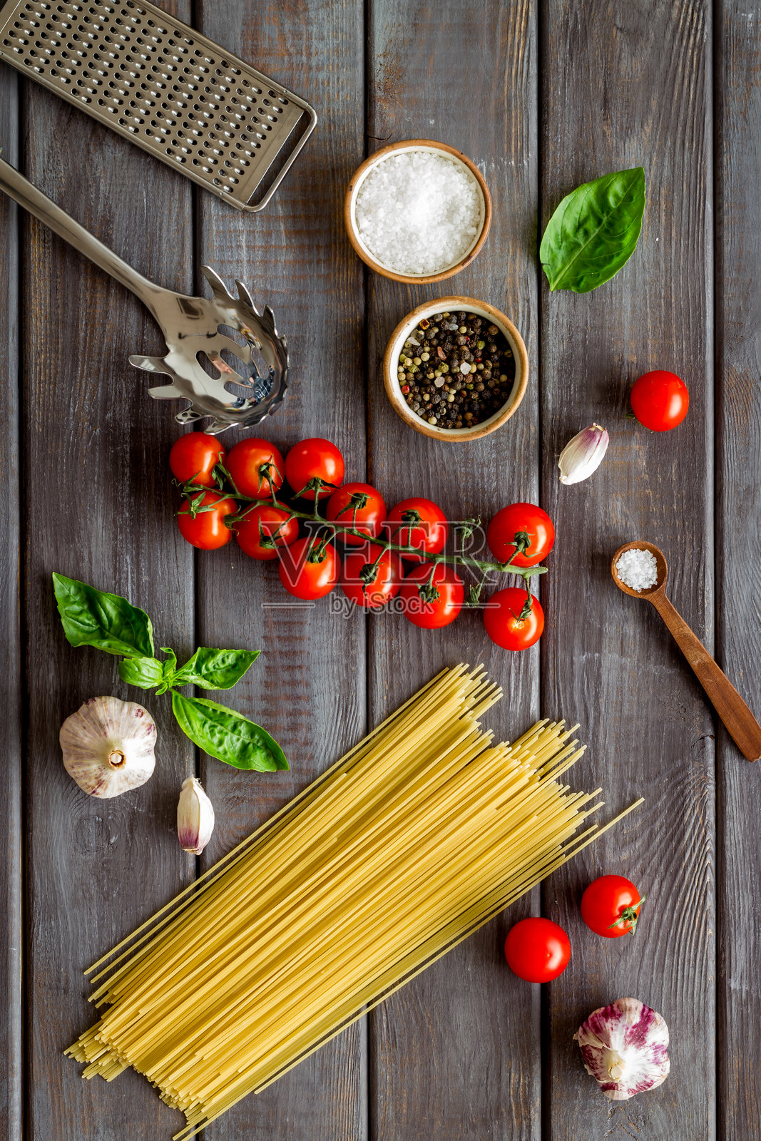 意大利面配料，包括番茄、罗勒和大蒜，摆放在木质背景上，俯视角度，平面拍摄。照片摄影图片