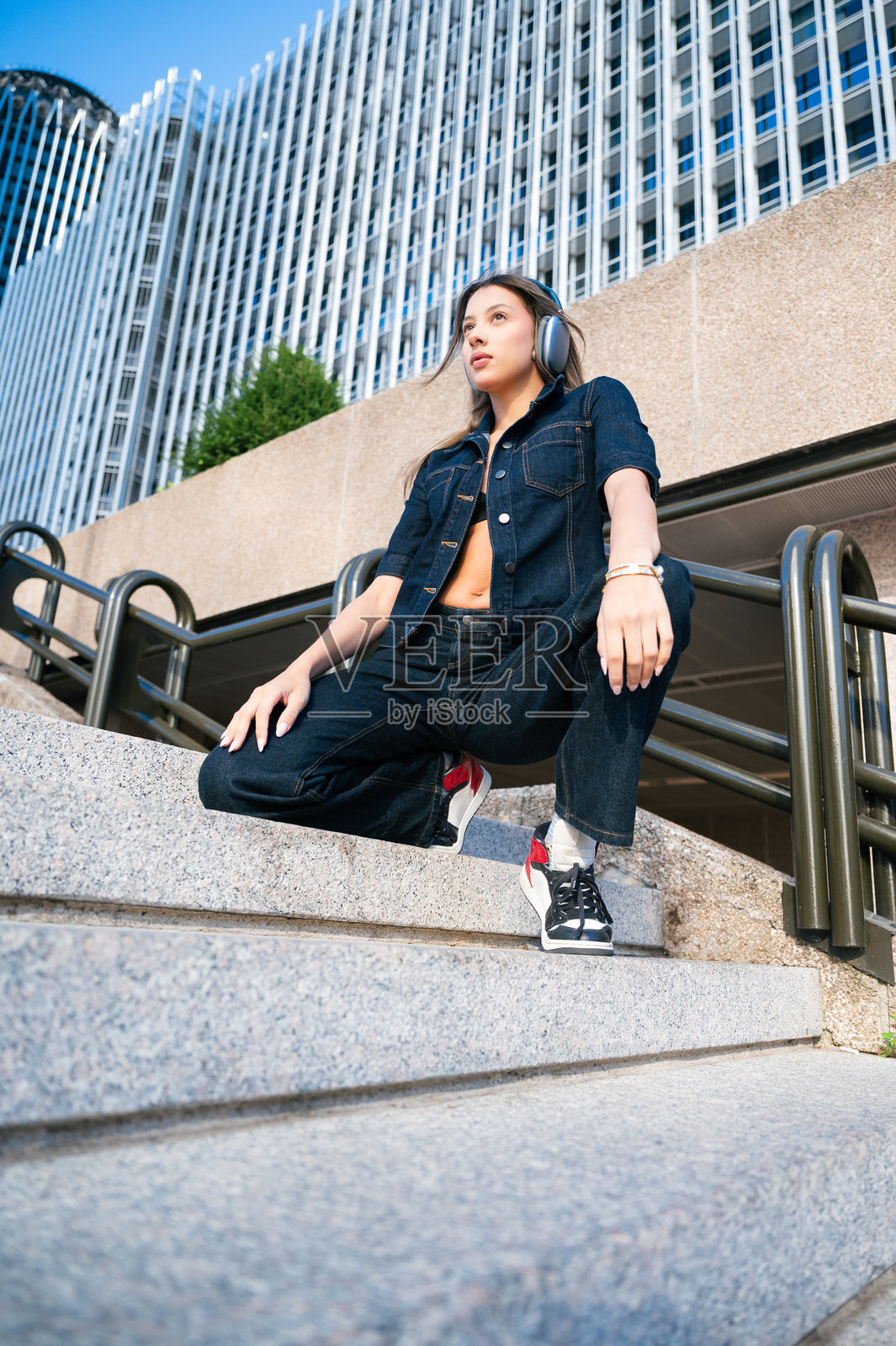 年轻女子戴着耳机听音乐，都市生活方式照片摄影图片