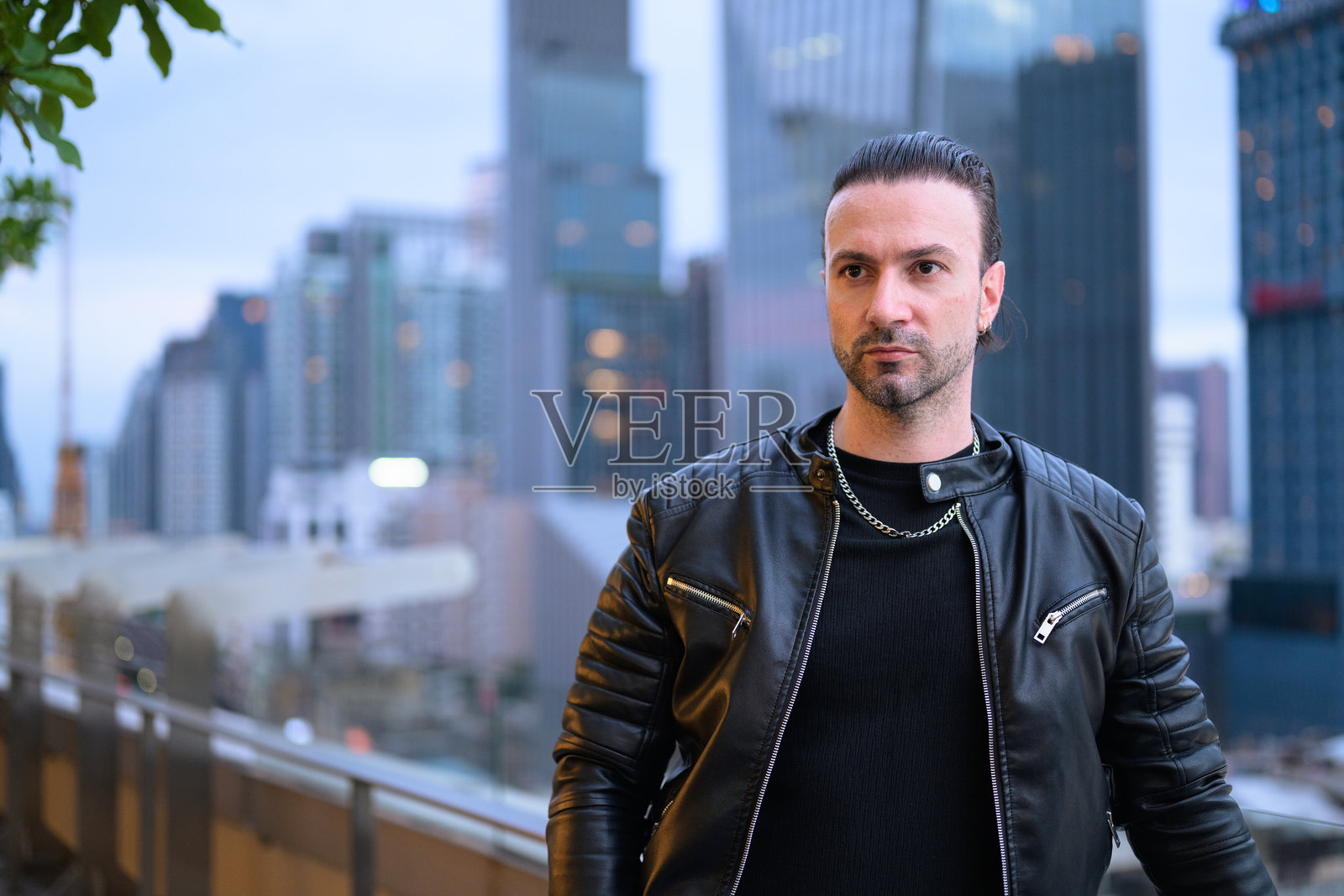 英俊的西班牙裔男子在建筑屋顶上的肖像照片摄影图片