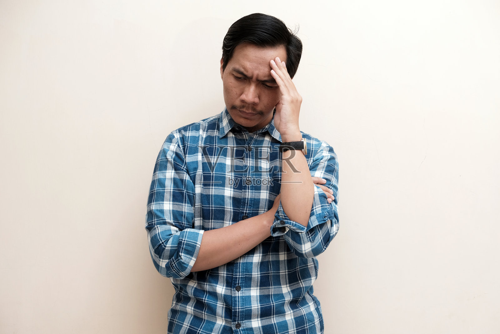 东南亚男子穿着法兰绒衬衫，表情显露压力照片摄影图片