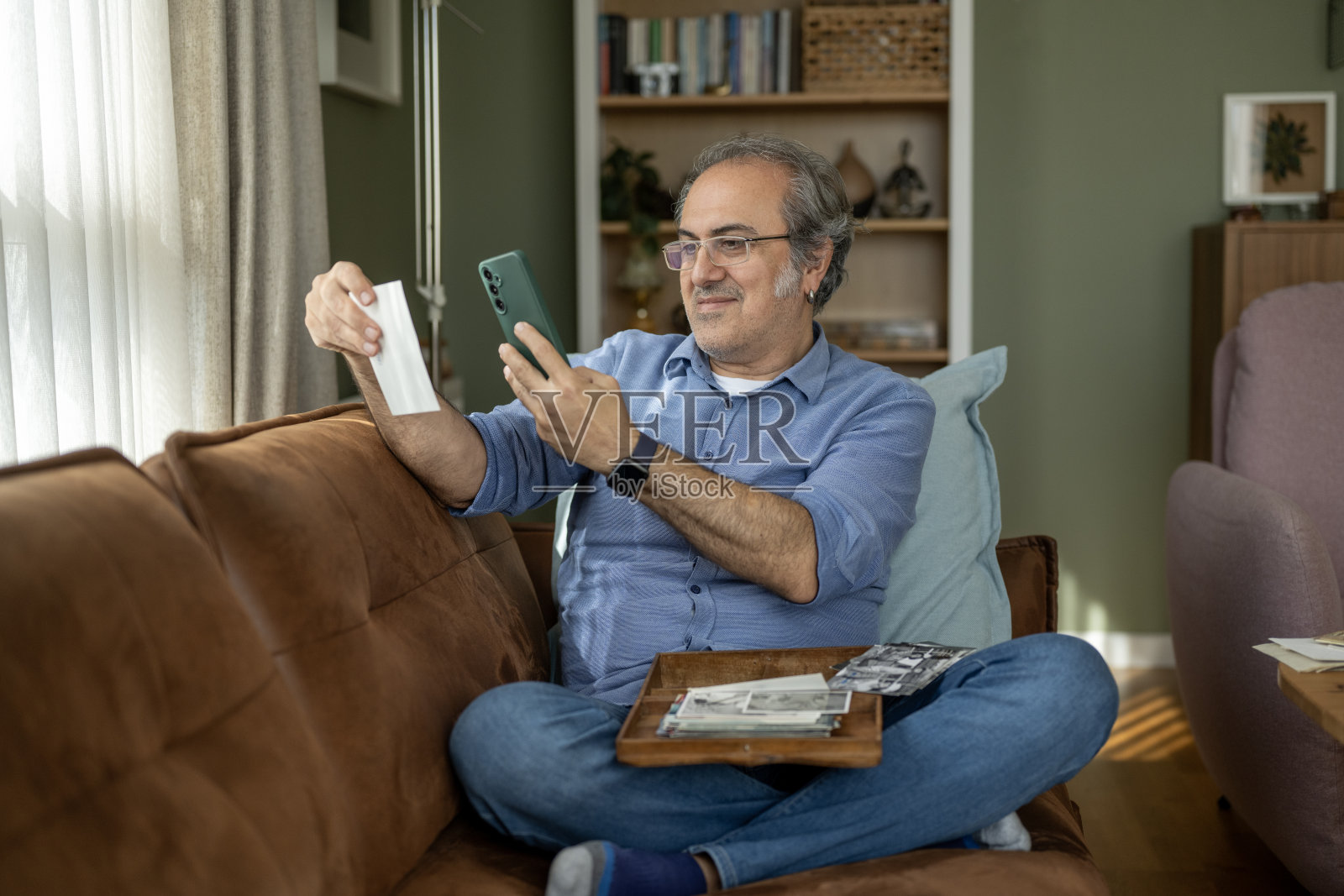 一位有阿尔茨海默病风险的男子正在看旧照片照片摄影图片