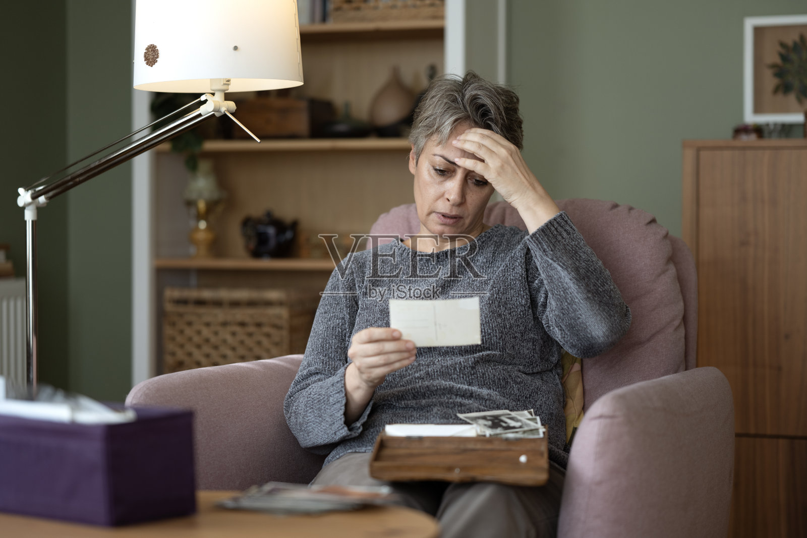 一位有阿尔茨海默病风险的女性，通过查看旧照片试图回忆过去。照片摄影图片