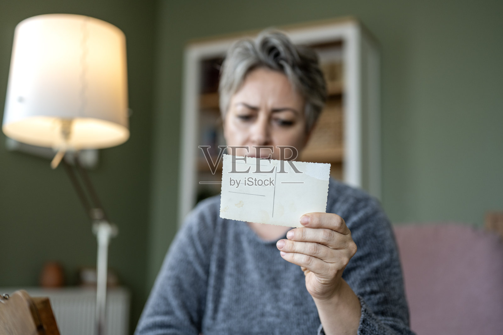 一名有阿尔茨海默病风险的女性，通过查看旧照片试图回忆过去。照片摄影图片