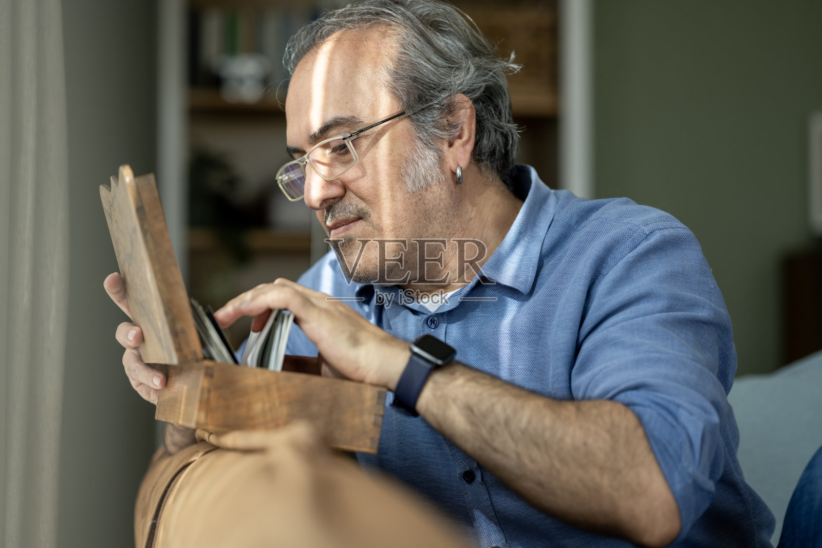 一位有阿尔茨海默病风险的男性正在看旧照片照片摄影图片