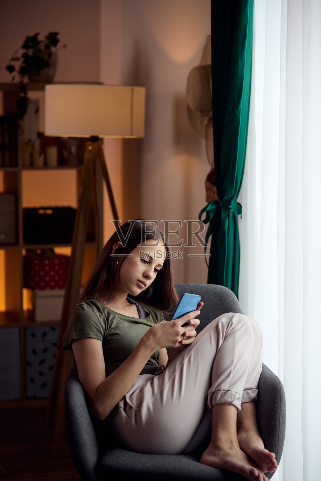 年轻女子在家中舒适的空间里放松地使用智能手机照片摄影图片