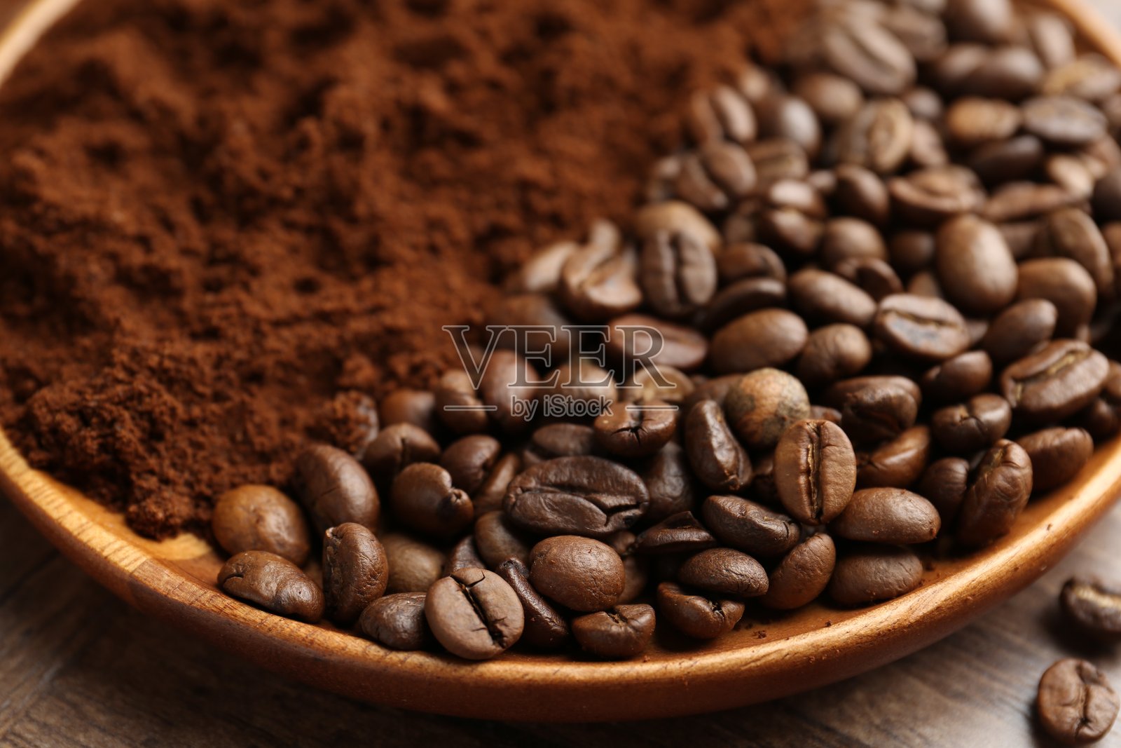 碗里的咖啡粉和烤咖啡豆放在木桌上，特写照片摄影图片