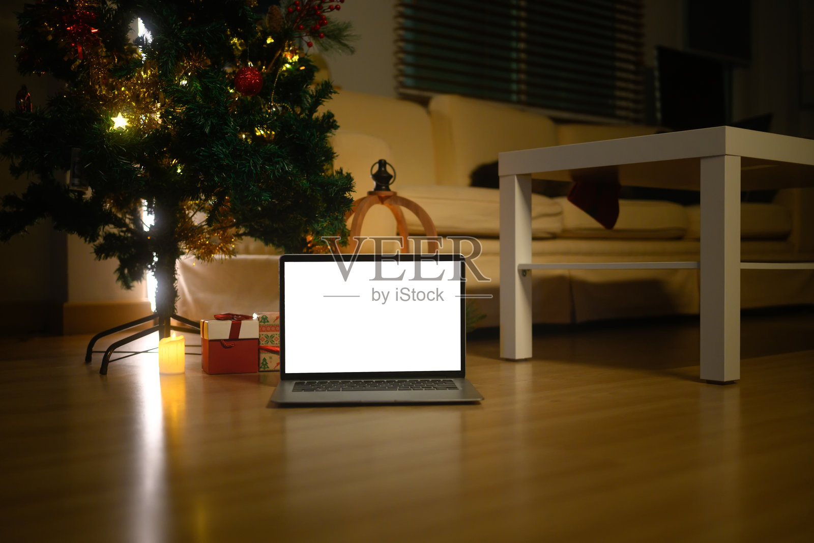 笔记本电脑正面特写，白色屏幕，居家背景，圣诞树，暖光，礼品盒，黑色星期五促销，在线购物照片摄影图片