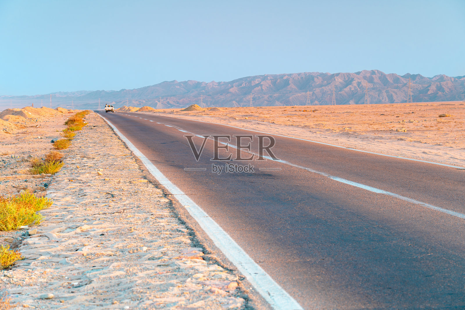 汽车载着人们行驶在通往山脉的沥青路上，埃及马萨阿拉姆，非洲。照片摄影图片