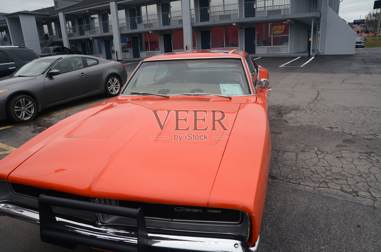 一辆亮橙色的道奇 Charger，造型是《霍克勇士》中的 General Lee照片摄影图片