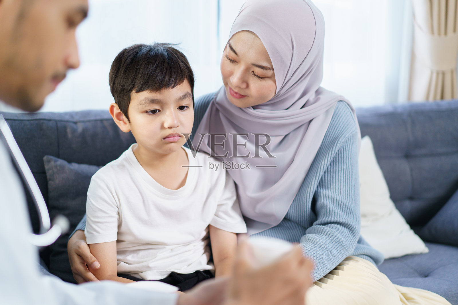 亚洲穆斯林女性带儿子去看医生照片摄影图片
