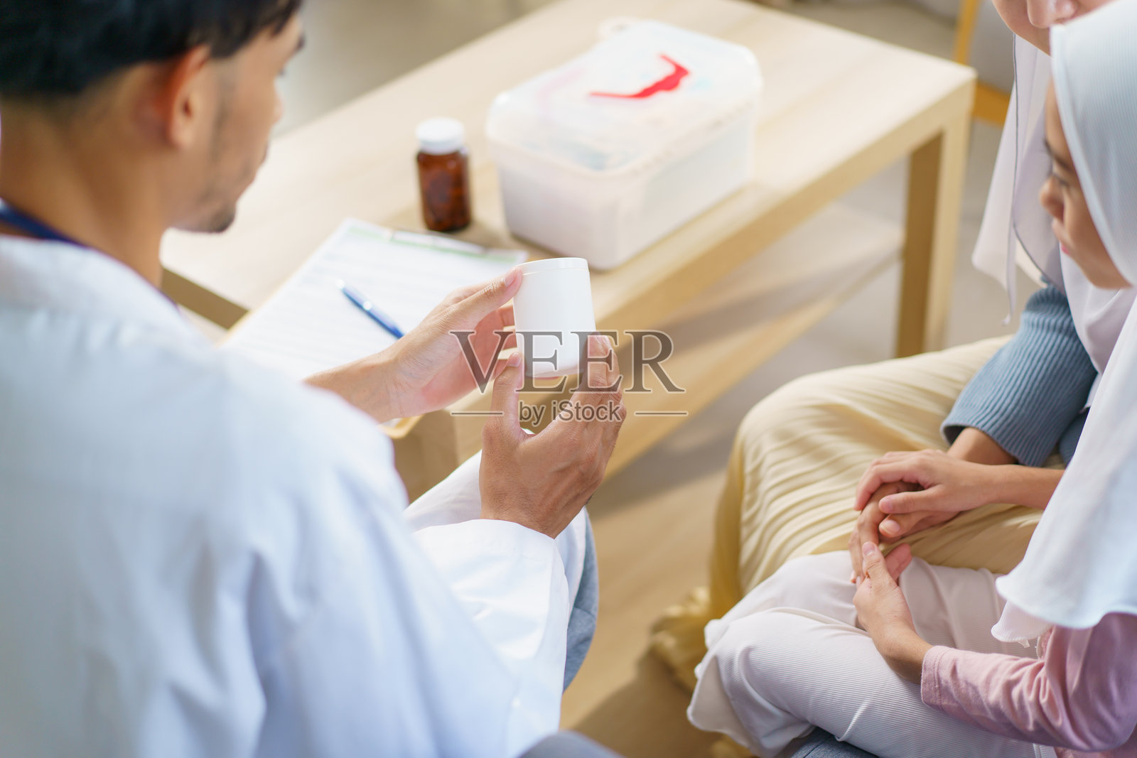 亚洲穆斯林女性带女儿去看医生，在医院里。照片摄影图片