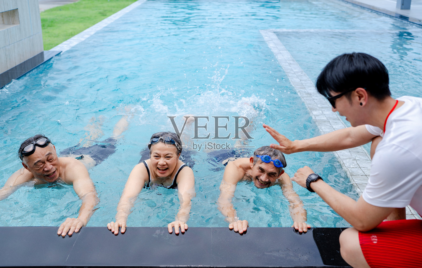 一群亚洲老年人在体育俱乐部的游泳池里游泳锻炼照片摄影图片