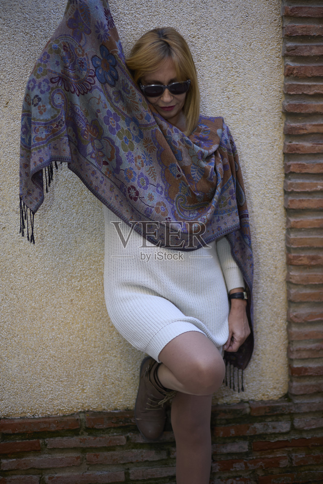 身穿毛衣连衣裙和印花披肩的女性摆拍照片摄影图片