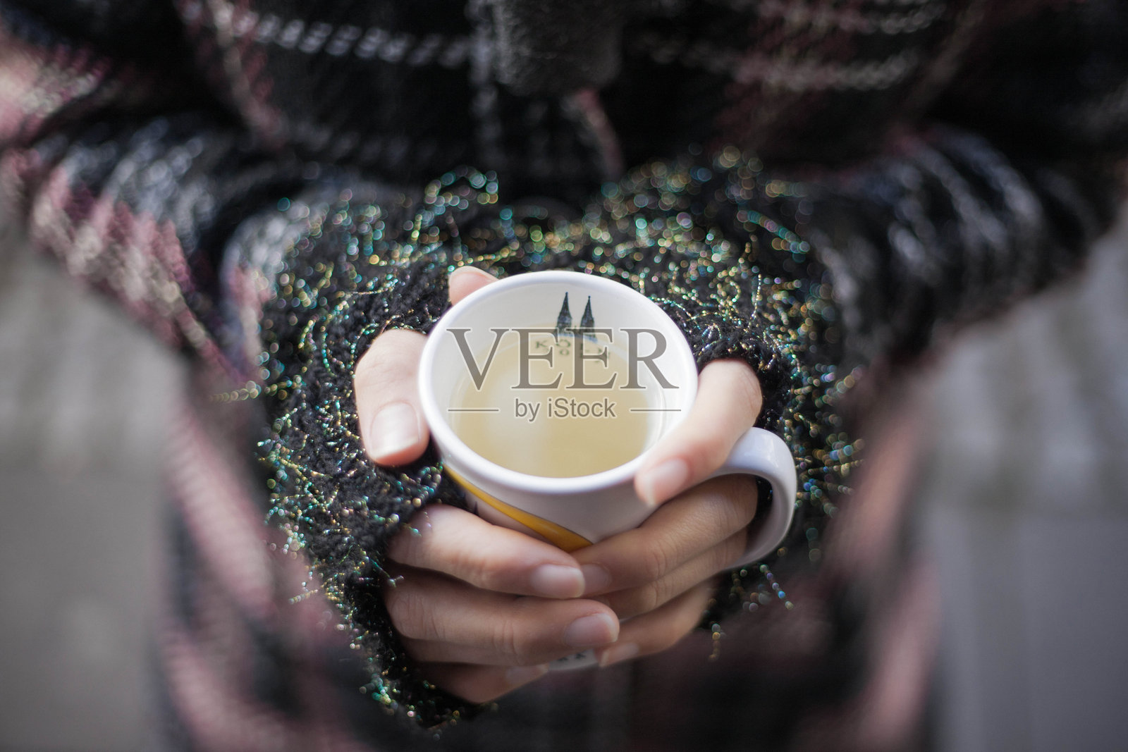 女性双手捧着热饮，戴着无指手套，穿着冬衣照片摄影图片