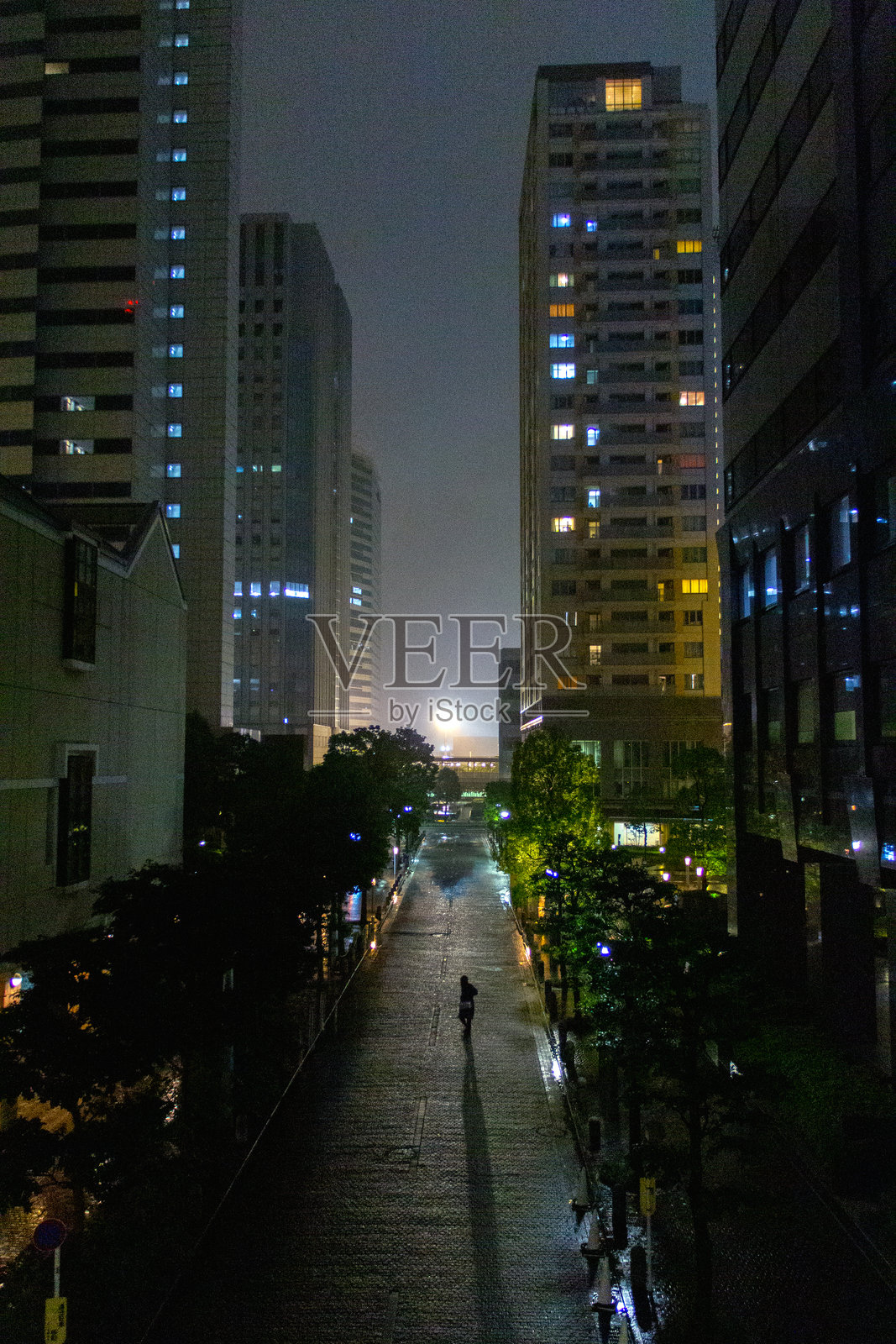 日出时分，独自一人行走在高楼大厦之间照片摄影图片