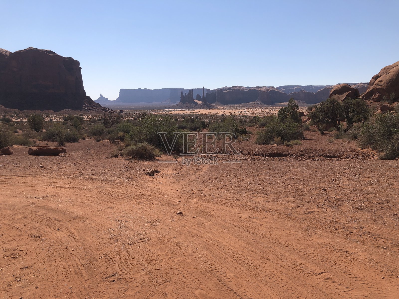 美国犹他州纪念碑谷部落公园内，有植被和山脉的沙漠景观照片摄影图片