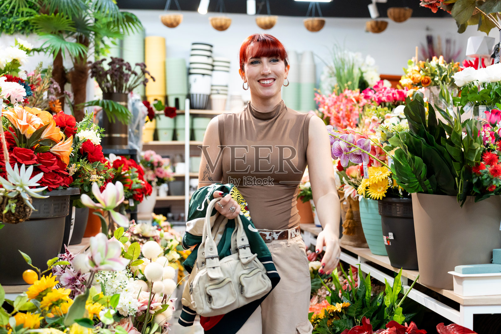 年轻女子在零售店选购仿真花照片摄影图片