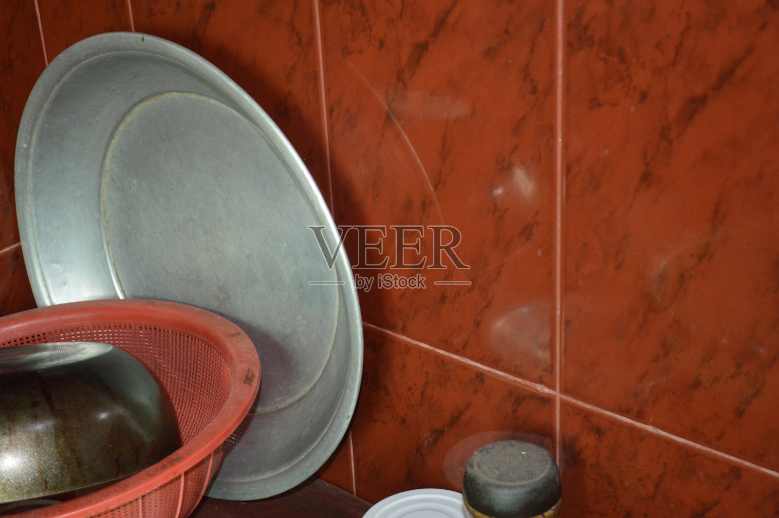 Metal Tray, Red Colander, and Plates in a Red-Tiled Kitchen, Food Prep Scene照片摄影图片