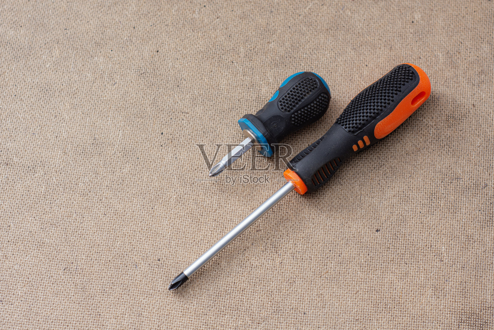 木质背景上的两把螺丝刀。专业手工工具，用于建筑、维修和DIY项目。照片摄影图片