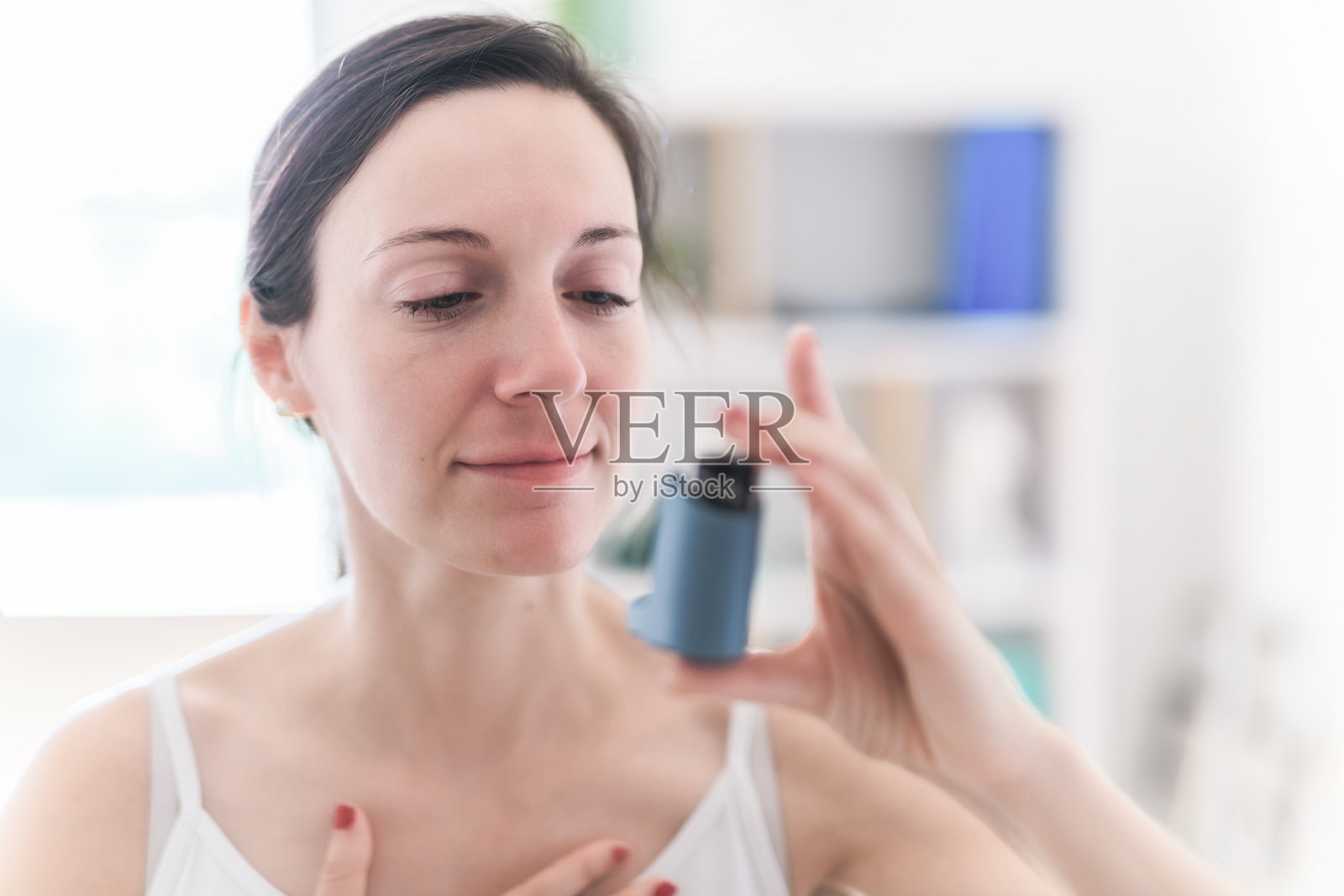 诊所里，一名女医生正在使用吸入器应对哮喘发作。照片摄影图片