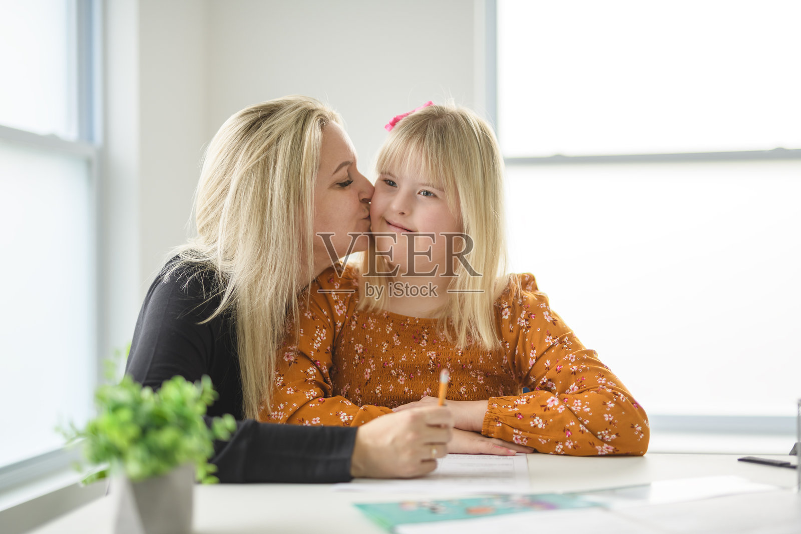 患唐氏综合征的母亲和女儿在享受发展课程时，快乐地绘画和微笑照片摄影图片