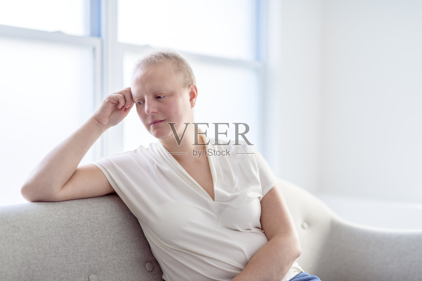 一位患有乳腺癌的悲伤女子在明亮的房间里照片摄影图片