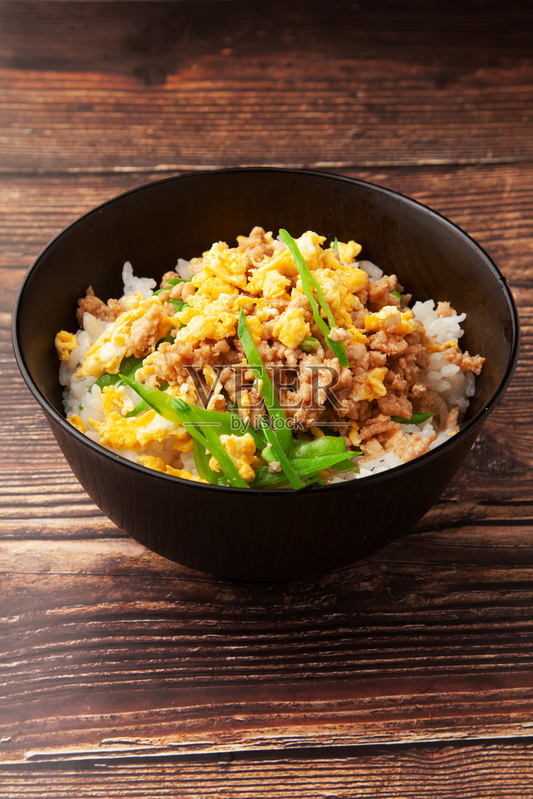 盖有鸡肉末、炒鸡蛋和青豆的米饭碗照片摄影图片