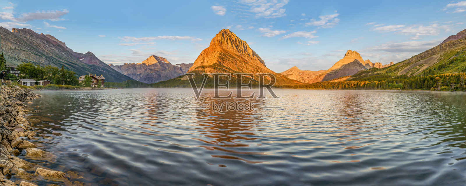 日出映照着冰川国家公园的斯威夫特卡伦特湖。照片摄影图片