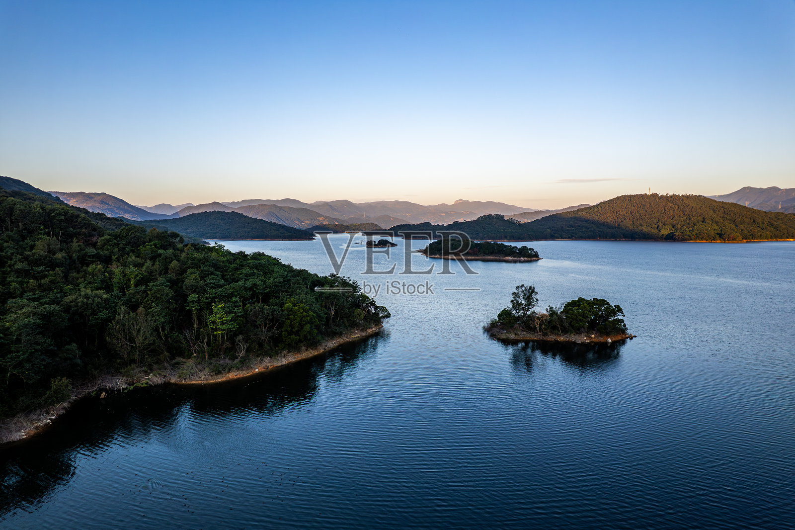 清晨时分，湖泊被森林环绕照片摄影图片