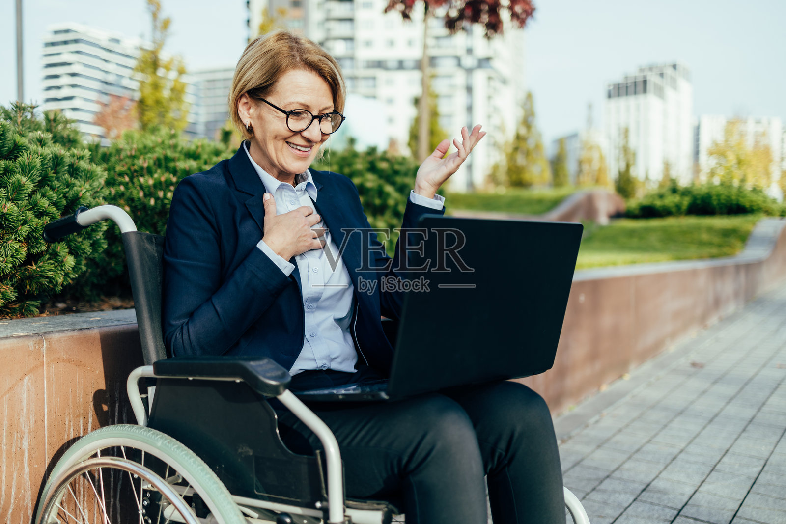 坐轮椅的人在户外用笔记本电脑进行视频通话照片摄影图片