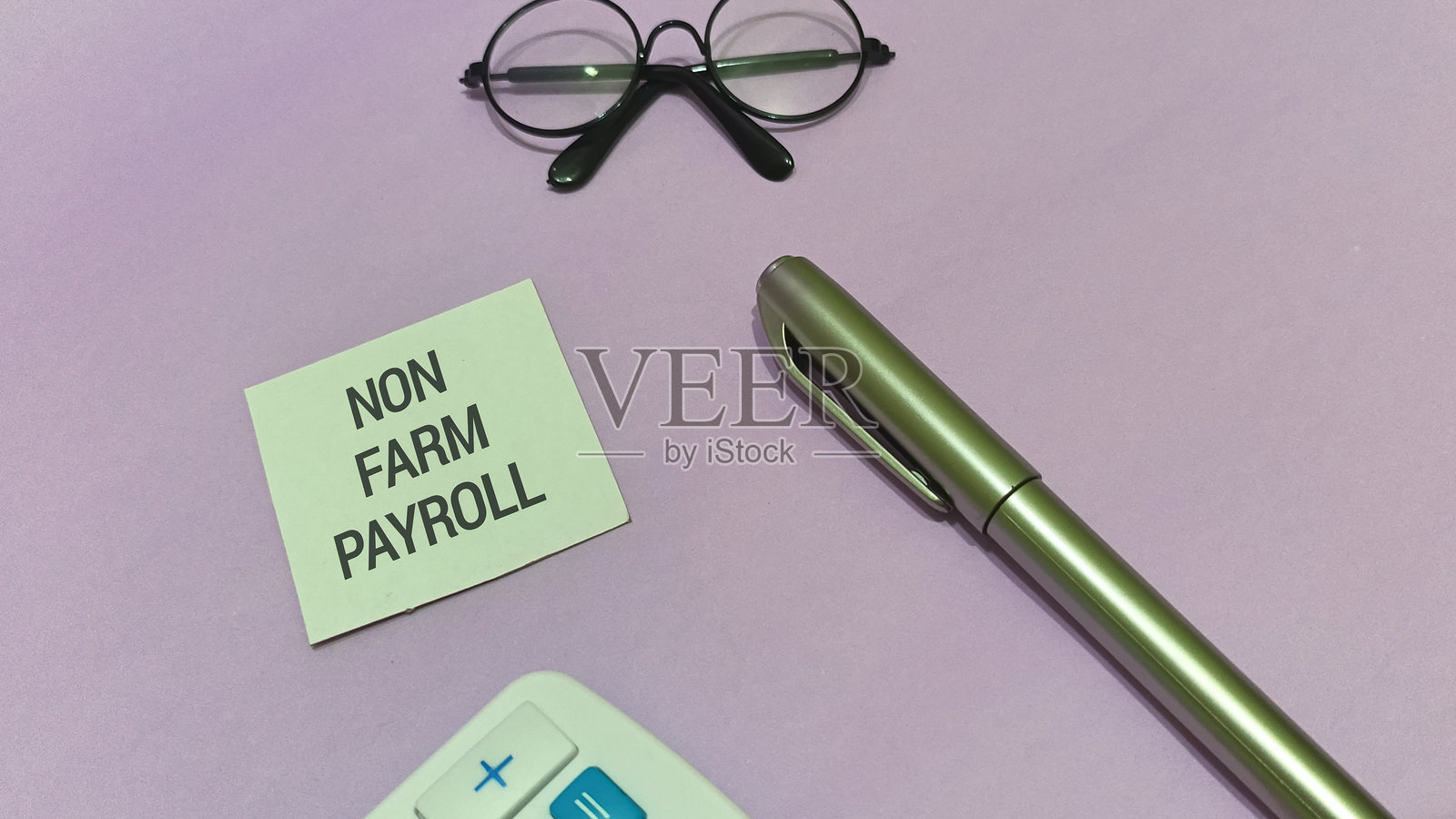 非农就业数据提醒，背景为丁香紫，配有计算器、钢笔和眼镜，用于商业和经济规划，包含金融数据照片摄影图片