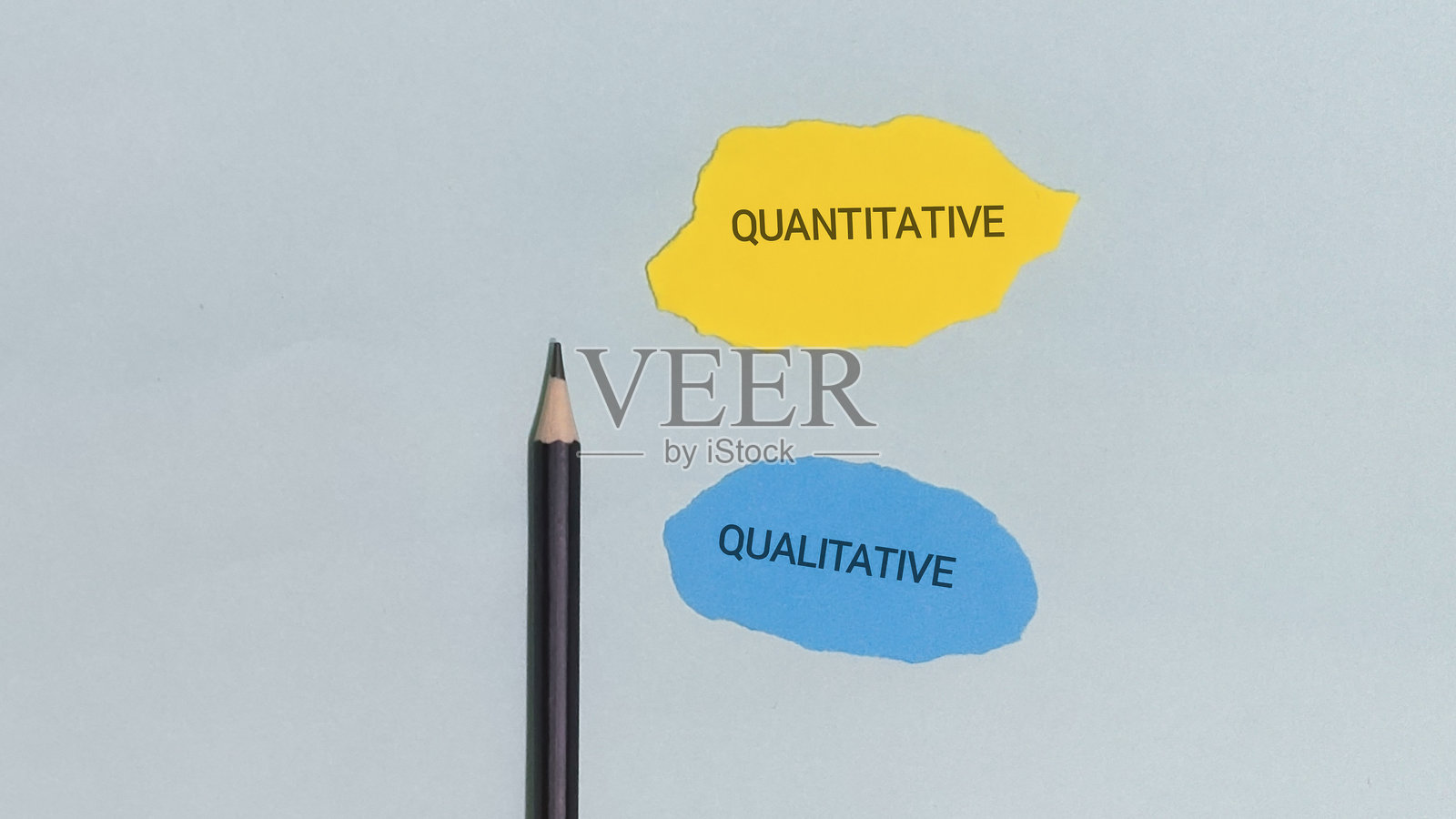 一支铅笔放在展示数量的黄色和蓝色纸张剪纸旁边。照片摄影图片