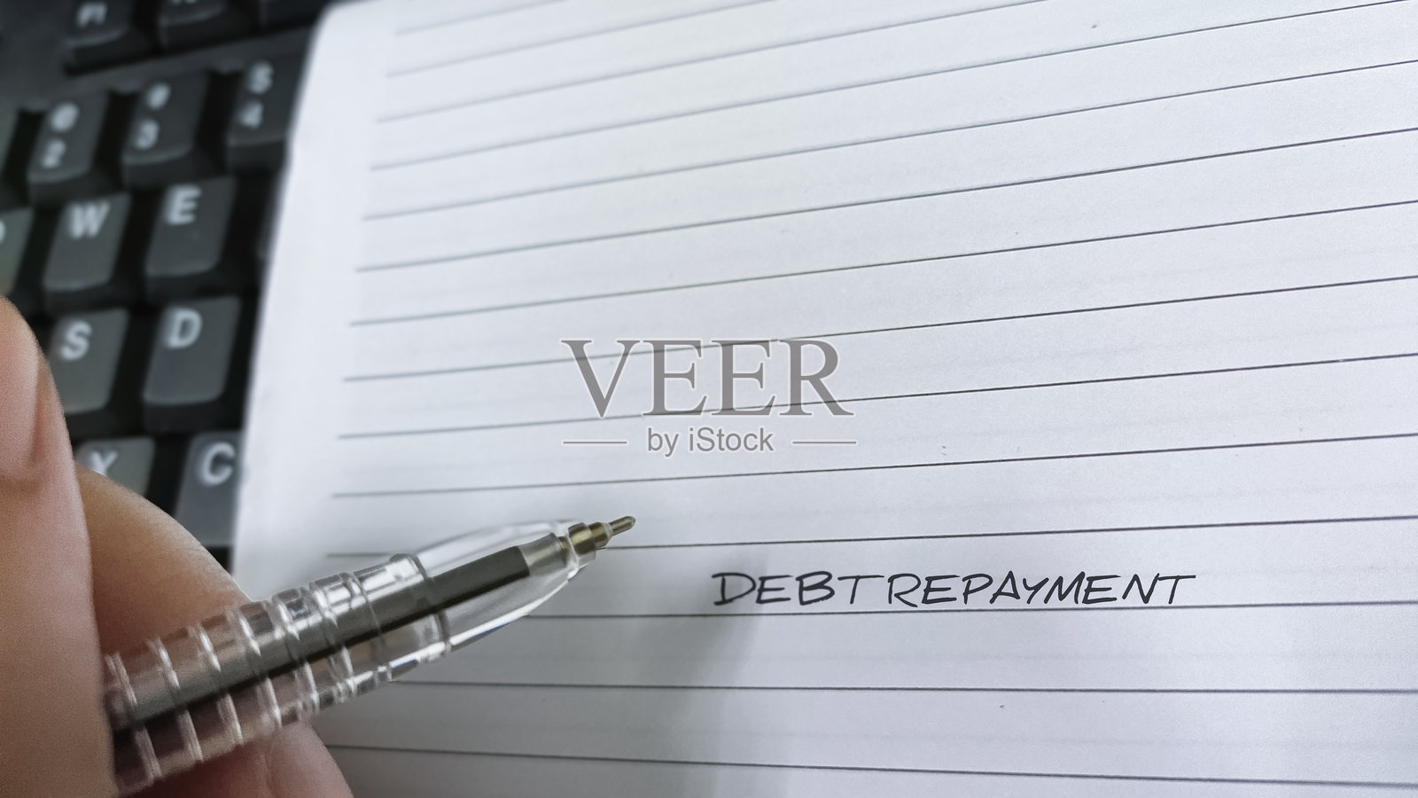 写着“偿还债务”的笔和笔记本，代表财务规划、责任和债务管理。照片摄影图片