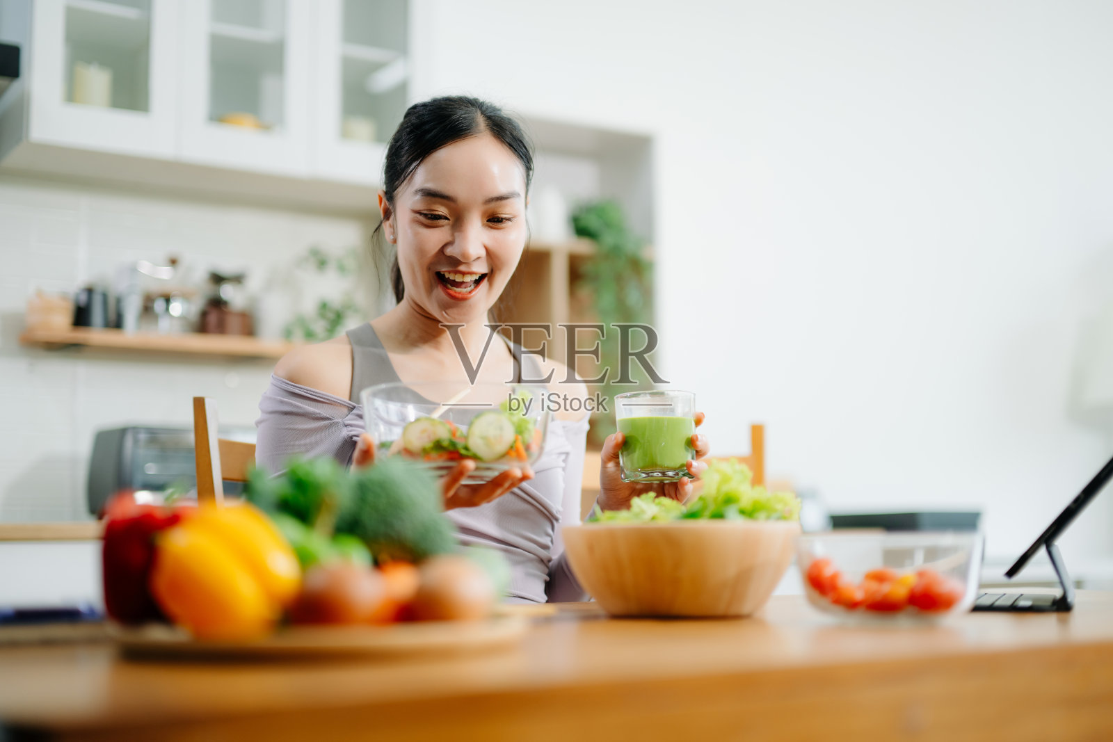 年轻女性在厨房记录健康食谱或每日定量饮食，在家积极进行健康清洁饮食。照片摄影图片