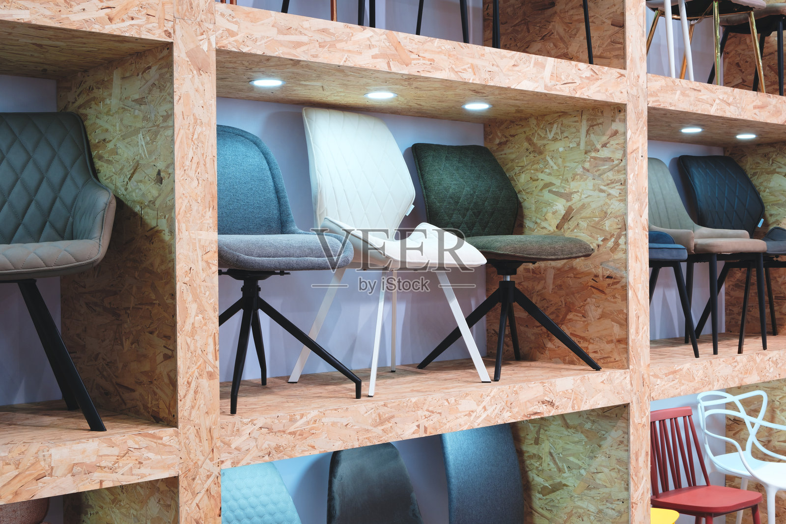 一排排木制货架上摆放着各种椅子，椅子颜色和风格各异。照片摄影图片