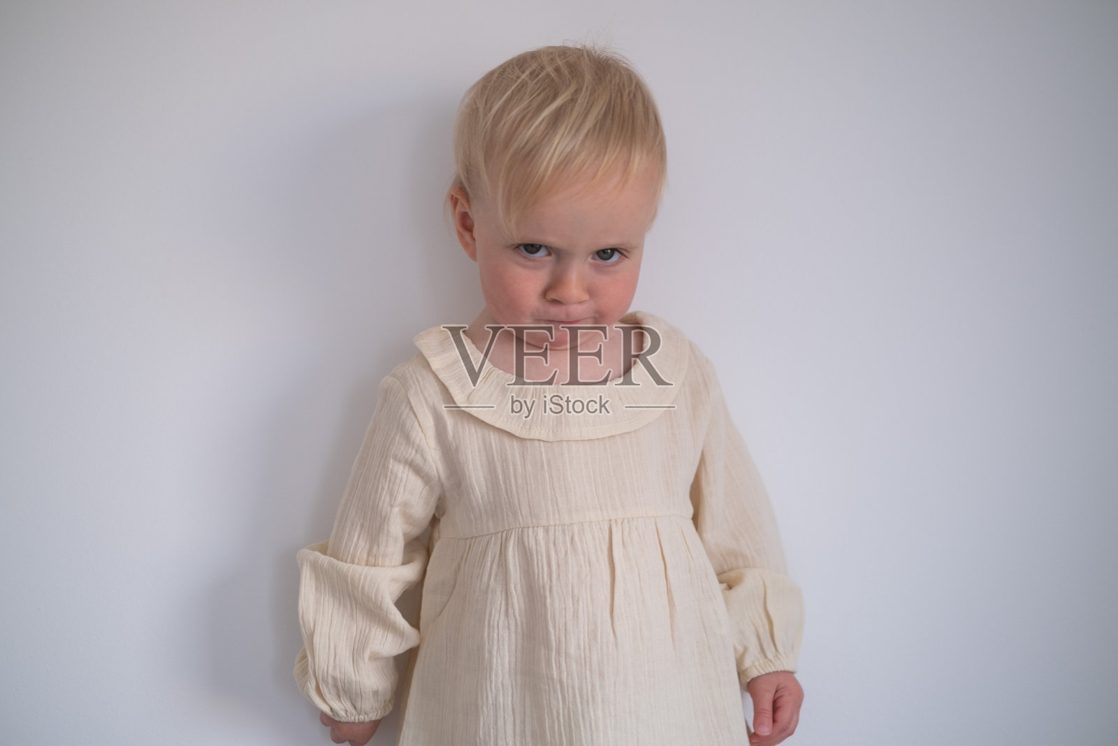 一个可疑又好奇的有趣的小女孩。照片摄影图片