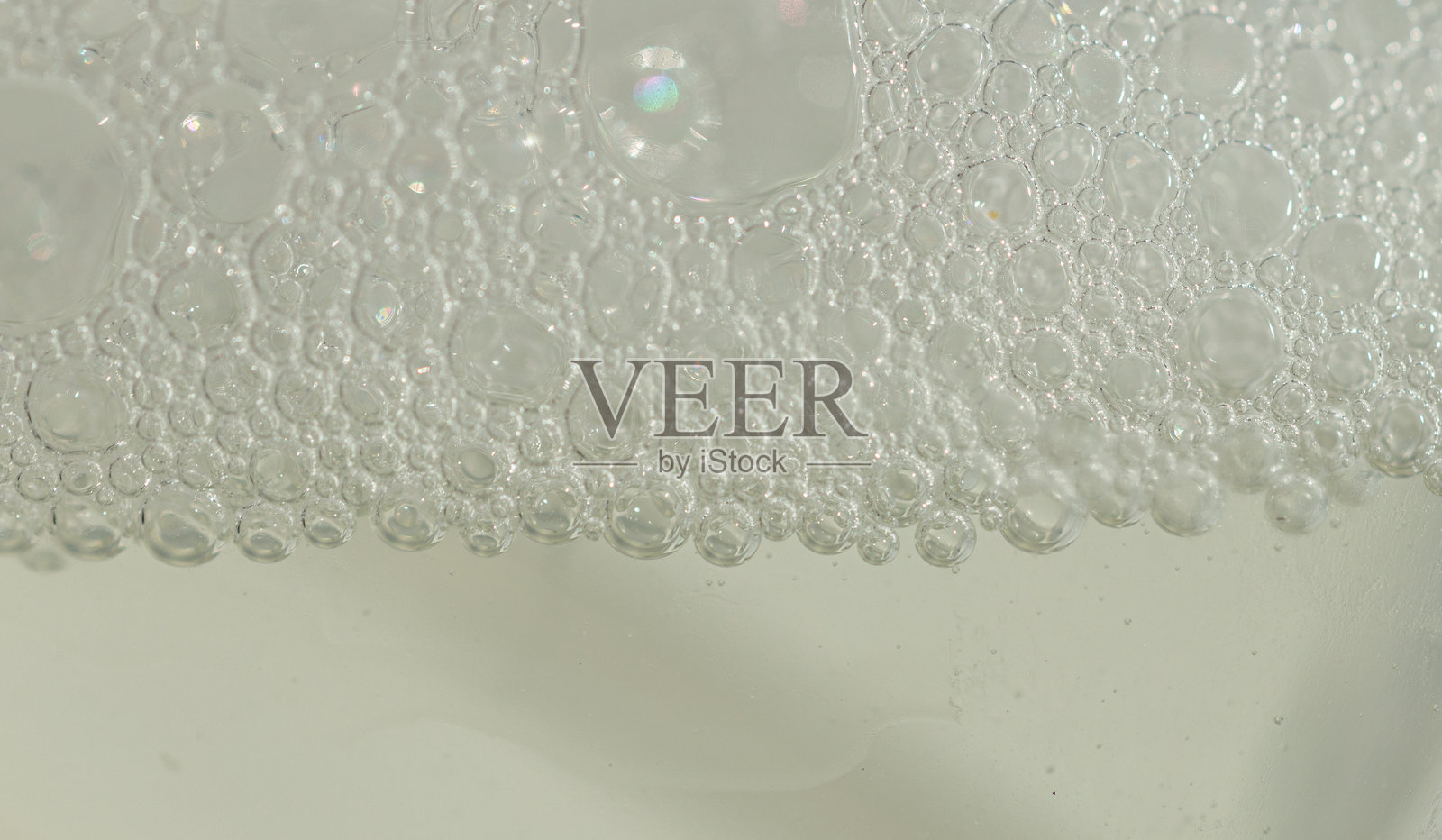 带有泡沫的黄色护发油瓶，洗发水，洁面乳，带有气泡的油的宏观纹理，化妆品纹理，护肤品液体照片摄影图片