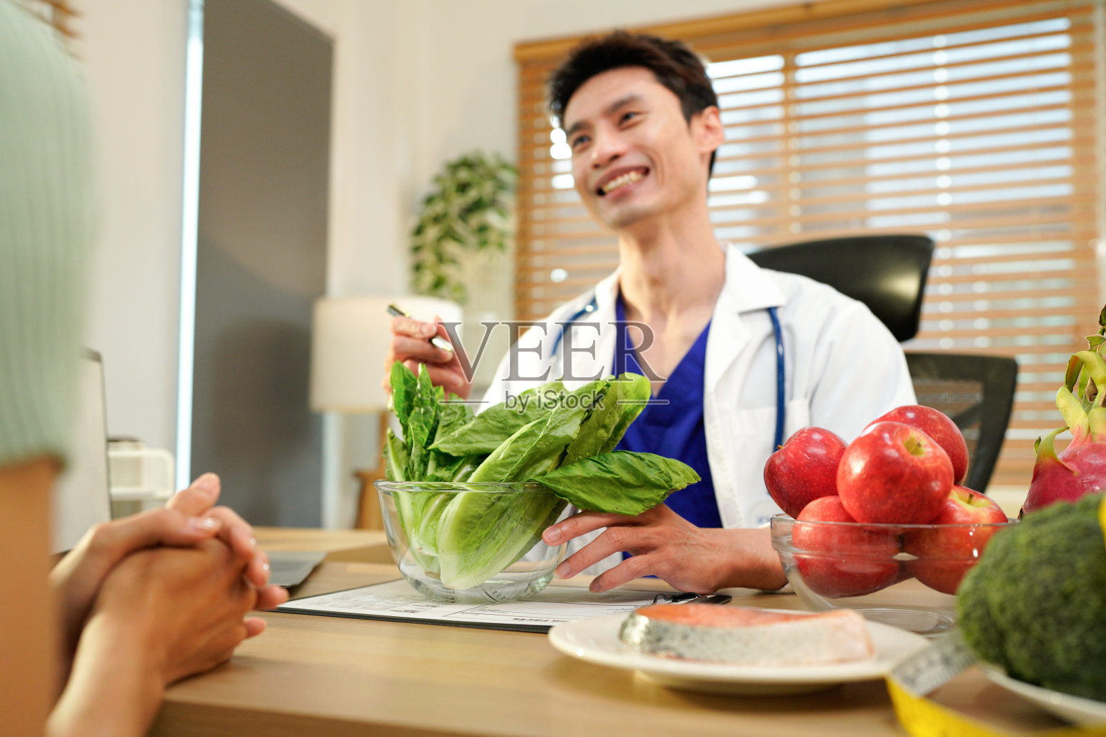 营养师向患者提供咨询，展示健康的果蔬，体现均衡营养和饮食理念照片摄影图片