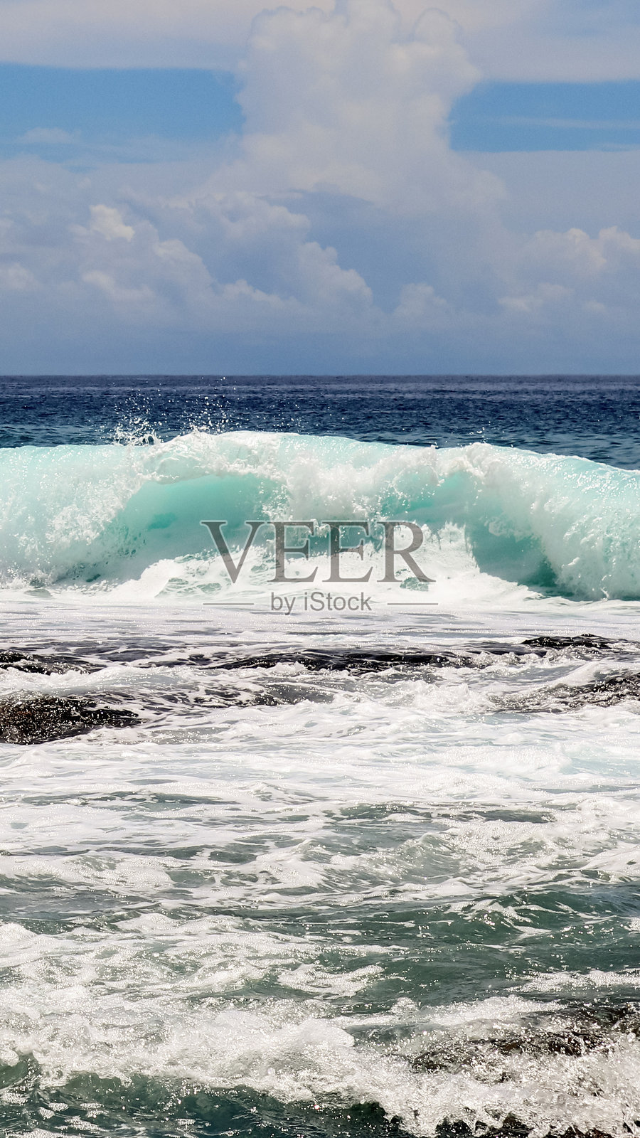 绿松石色的海浪拍打在岩石上照片摄影图片