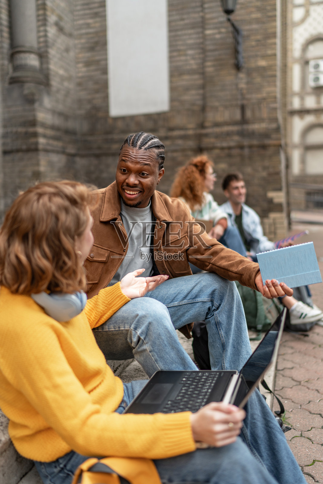 不同背景的学生们在大学校园里交谈和学习照片摄影图片