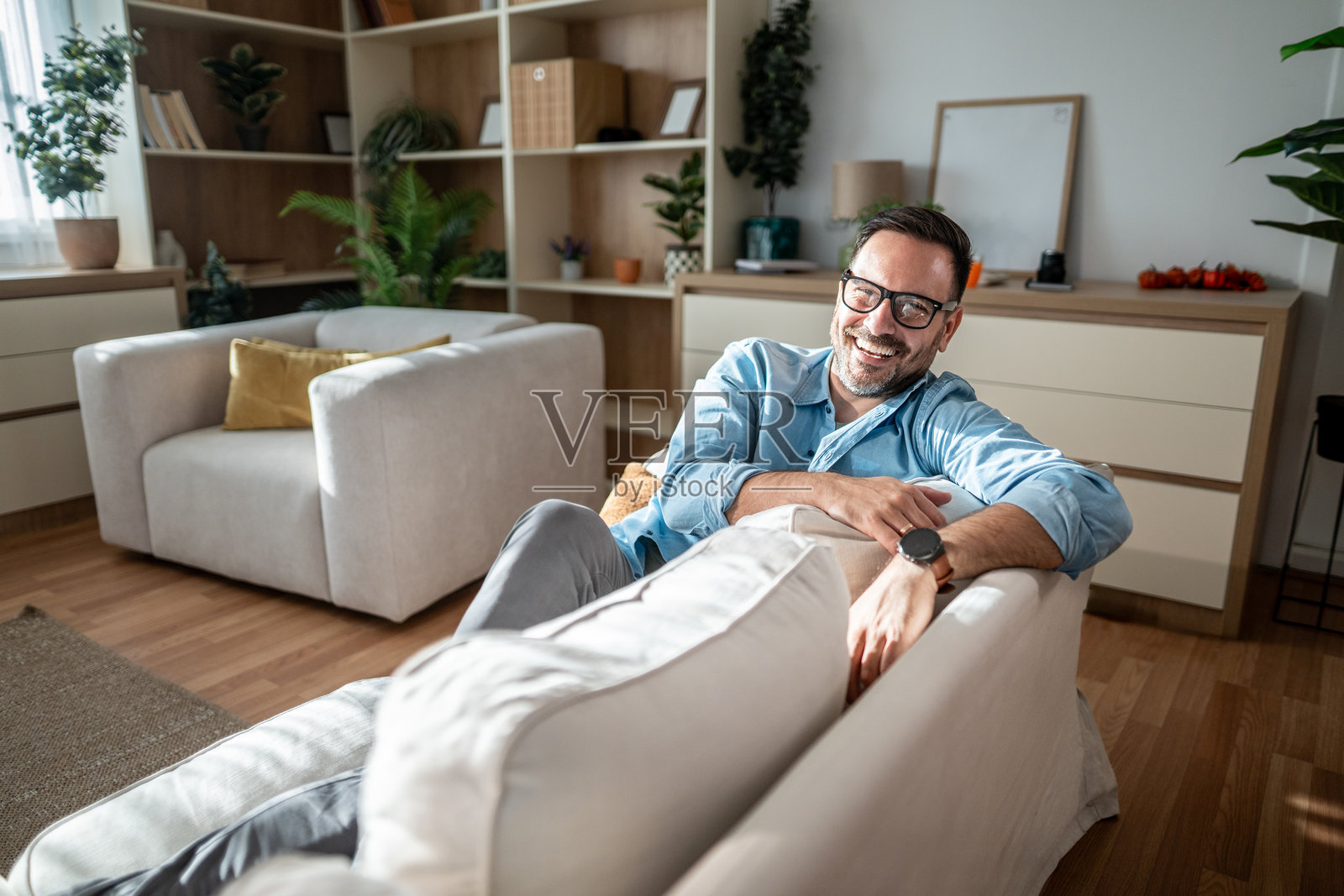 快乐的男人在客厅的沙发上放松照片摄影图片
