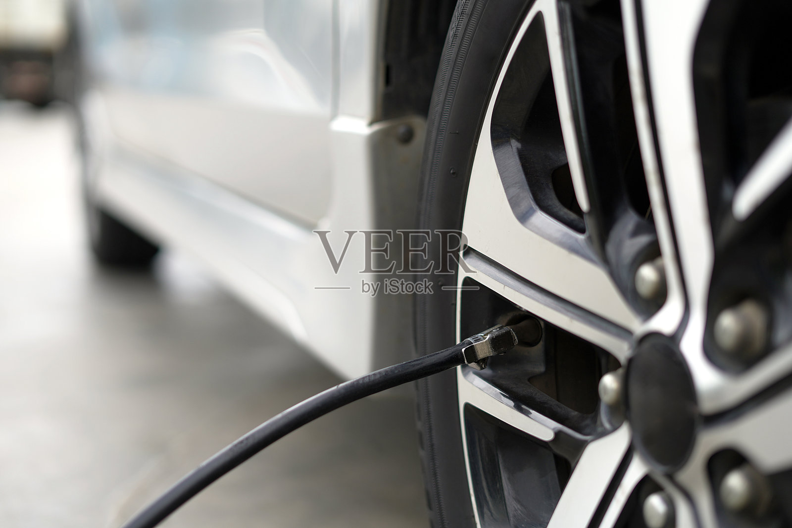 在出行前给爱车轮胎充气，以节省燃料。照片摄影图片