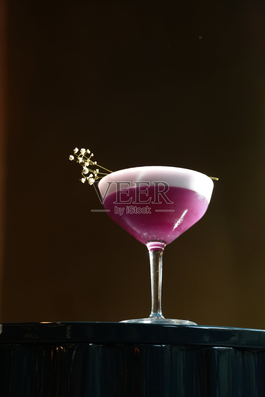 深色背景下，郁金香杯中盛放着泡沫优雅的紫色鸡尾酒照片摄影图片