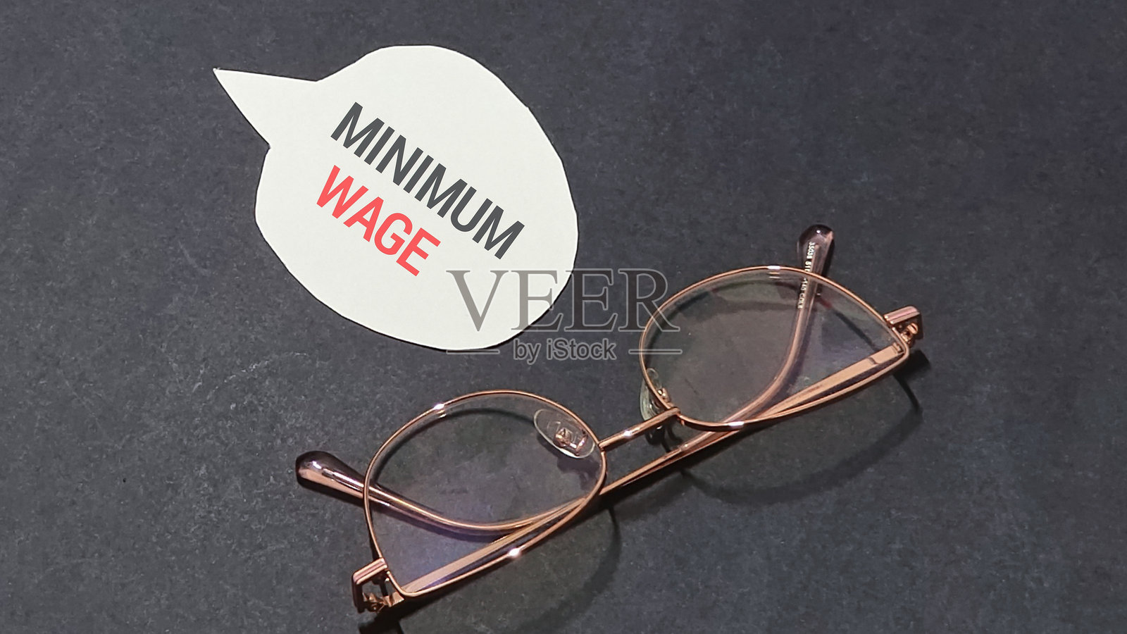 在简约背景下，戴着时尚眼镜倡导公平最低工资，旨在促进经济正义和社会平等运动。照片摄影图片