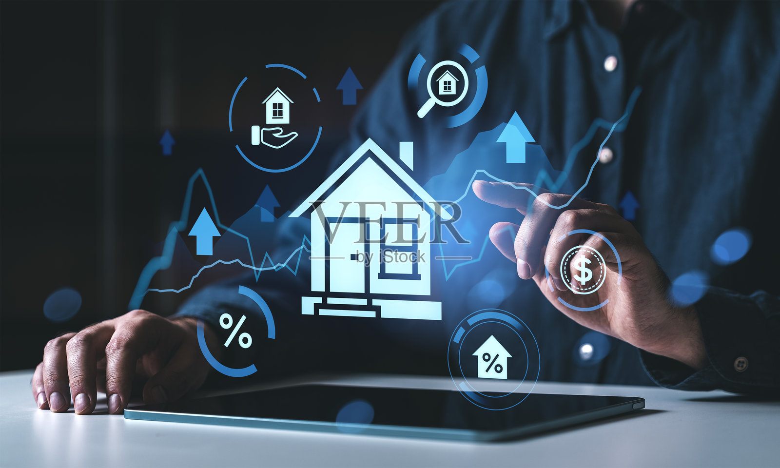 商务人士在现代办公空间使用平板电脑进行房地产投资的概念，屏幕上显示着数字全息房屋和金融图标。照片摄影图片