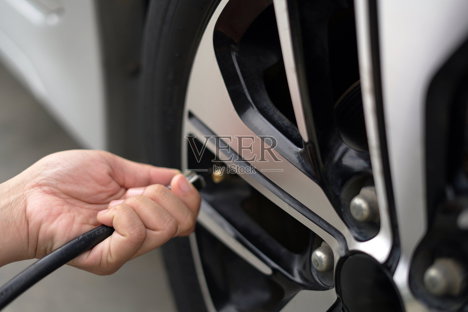 出行前给爱车的轮胎充气以节省燃油。照片摄影图片